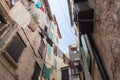 Colored laundry hanging out on a clothesline in the street between old houses. The traditional view of the city. Rovinj