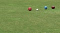 Colored lawn bowls in a line with the white ball known as the jack Royalty Free Stock Photo