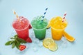 Colored lemonades in plastic cups with ice, fruits and berries