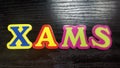 colored letters form the word Xmas on black wooden background