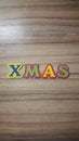 colored letters form the word Xmas on wooden background