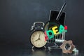 Colored letters of IDEA with clock, magnifying glass, smartphone, gears in a basket on a black background Copy space Royalty Free Stock Photo