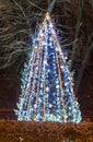 Colored lighted Christmas tree with blue ornaments, outdoor nigh Royalty Free Stock Photo