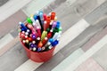 Colored markers in a metal bucket.