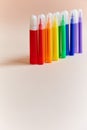 Colored markers thin thick red yellow green pink blue purple light background.