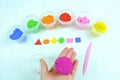 Colored mass for modeling, plasticine for children`s creativity, the child makes colored geometric shapes,  yellow background Royalty Free Stock Photo