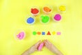 Colored mass for modeling, plasticine for children`s creativity, the child makes colored geometric shapes,  yellow background Royalty Free Stock Photo