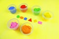 Colored mass for modeling, plasticine for children`s creativity, the child makes colored geometric shapes,  yellow background Royalty Free Stock Photo