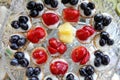 Colored mini tarts with strawberry, ananas and grapes on a table.