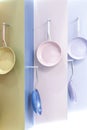 Colored new clean multi-colored pans hang on a store showcase. Kitchen utensils, metal kitchenware for cooking, household goods Royalty Free Stock Photo