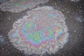Colored oil stain on the asphalt. A rainbow slick of gasoline. Royalty Free Stock Photo