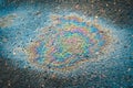 Colored oil stain on the asphalt. A rainbow slick of gasoline. Royalty Free Stock Photo