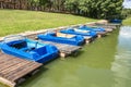 Colored old vintage plastic catamarans and boats near a wooden pier on the shore of a large lake