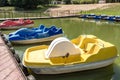 Colored old vintage plastic catamarans and boats near a wooden pier on the shore of a large lake