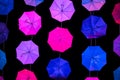 Colored open umbrellas on dark background.