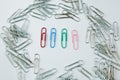 Colored Paper Clip among ordinary clips, which implies either it being a leader or a black sheep in group Royalty Free Stock Photo