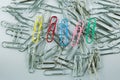 Colored Paper Clip among ordinary clips, which implies either it being a leader or a black sheep in group Royalty Free Stock Photo