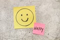 Colored paper notes with happy drawing face and single word on a gray marble background Royalty Free Stock Photo