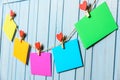 Colored paper sheets on thread with heart shaped clothespin blue wooden background Royalty Free Stock Photo
