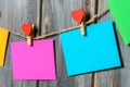 Colored paper sheets on thread with heart shaped clothespin wooden background Royalty Free Stock Photo