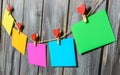 Colored paper sheets on thread with heart shaped clothespin wooden background Royalty Free Stock Photo