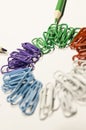 Colored paperclips in a circle and pencils Royalty Free Stock Photo