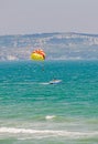 Colored parasail wing pulled by a boat in the blue water sea. Royalty Free Stock Photo