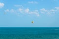 Colored parasail wing pulled by a boat in the sea water, Parasailing also known as parascending or parakiting.