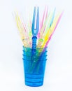 Colored party sticks in colored blue cups on a white background