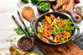 Colored pasta with peas and vegetables in a black bowl. Top view. Royalty Free Stock Photo