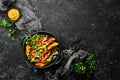 Colored pasta with peas and vegetables in a black bowl. Top view. Royalty Free Stock Photo