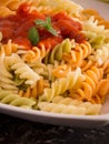 Colored pasta with tomato sauce on plate close up Royalty Free Stock Photo
