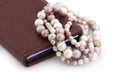 Colored pearls and a mobile phone on a white background. Royalty Free Stock Photo