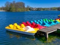 Colored pedalos or pedal boats on a lake are waiting for tourists