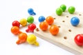 Colored pegs board, wood beads on white background