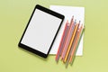 Colored pencil , blank notebook and computer tablet