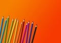 Colored pencil group isolated on orange. Horizontal background