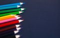 Colored pencils against dark blue background. Close up and selective focus Royalty Free Stock Photo