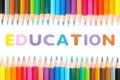Colored pencils with alphabet sponge rubber of text `EDUCATION ` over white background Royalty Free Stock Photo