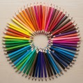 Colored pencils arranged in a circular pattern on a light wooden background Royalty Free Stock Photo
