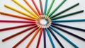 Colored pencils arranged in a circular pattern on a white surface Royalty Free Stock Photo