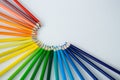 Colored pencils arranged in semi circle on white background Royalty Free Stock Photo