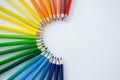 Colored pencils arranged in semi circle on white background Royalty Free Stock Photo