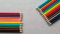 Colored pencils are arranged in two groups on a textured gray surface Royalty Free Stock Photo
