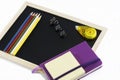 Colored pencils, black board, notebook and memopad Royalty Free Stock Photo