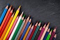 Colored pencils on a black stone slate Royalty Free Stock Photo