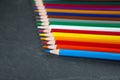 Colored pencils on a black stone slate Royalty Free Stock Photo