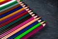 Colored pencils on a black stone slate Royalty Free Stock Photo