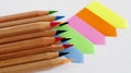 Colored pencils on block of bright multicolored blank stickers