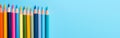 Colored pencils on a blue background, top view with copy space Royalty Free Stock Photo